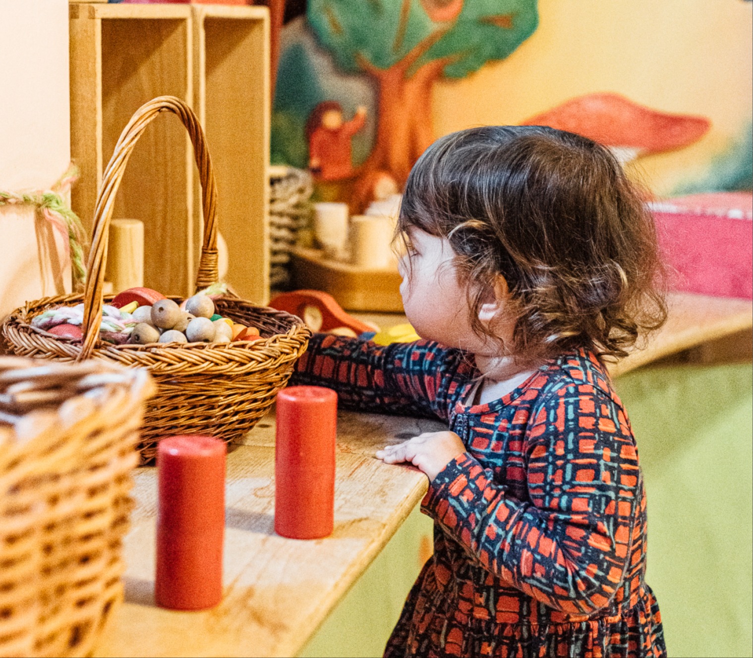 Klein kindje speelt aan een vensterbank met houten speelgoed